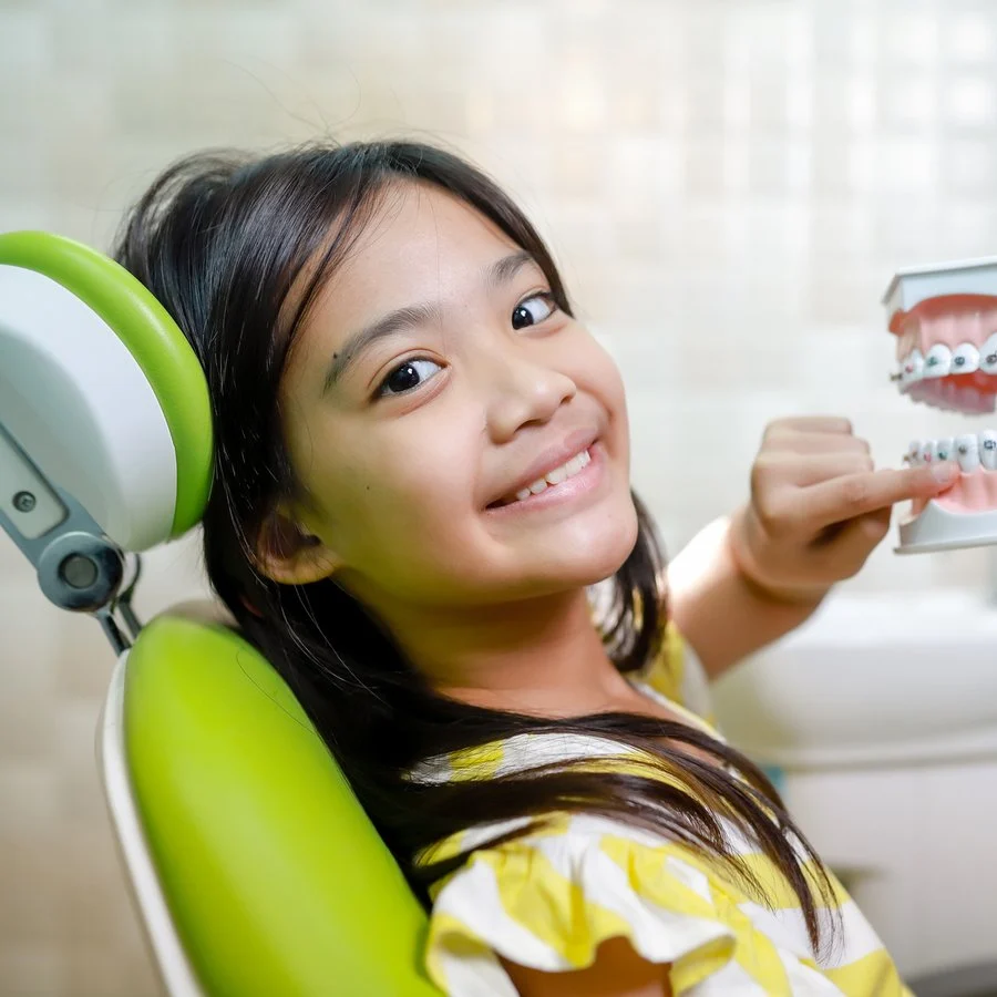 Smiling young girl sitting in a dental chair ready for a checkup