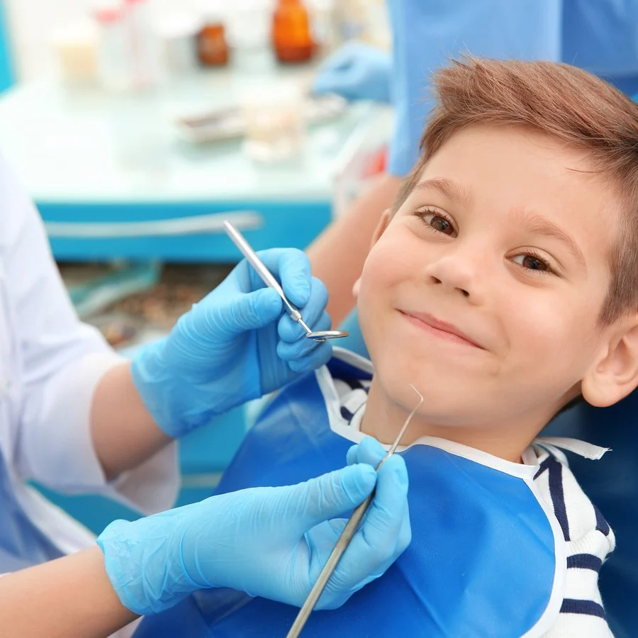 Dentist examining a little boy’s teeth in the clinic