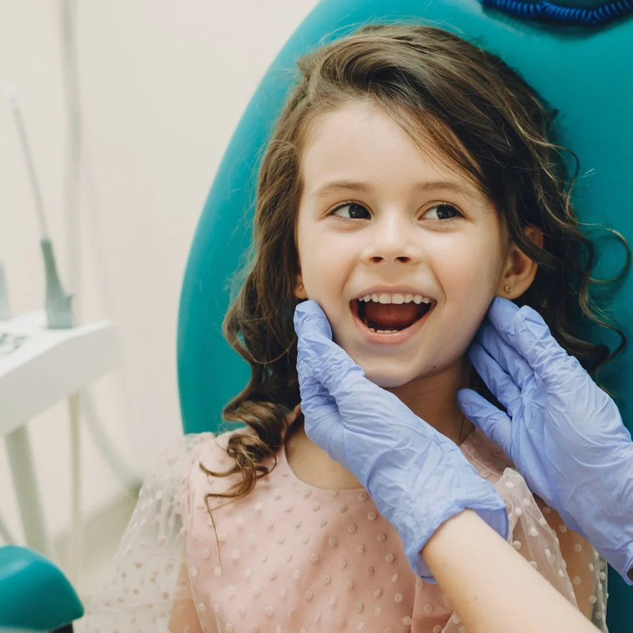 Young girl showing her teeth to the pediatric dentist